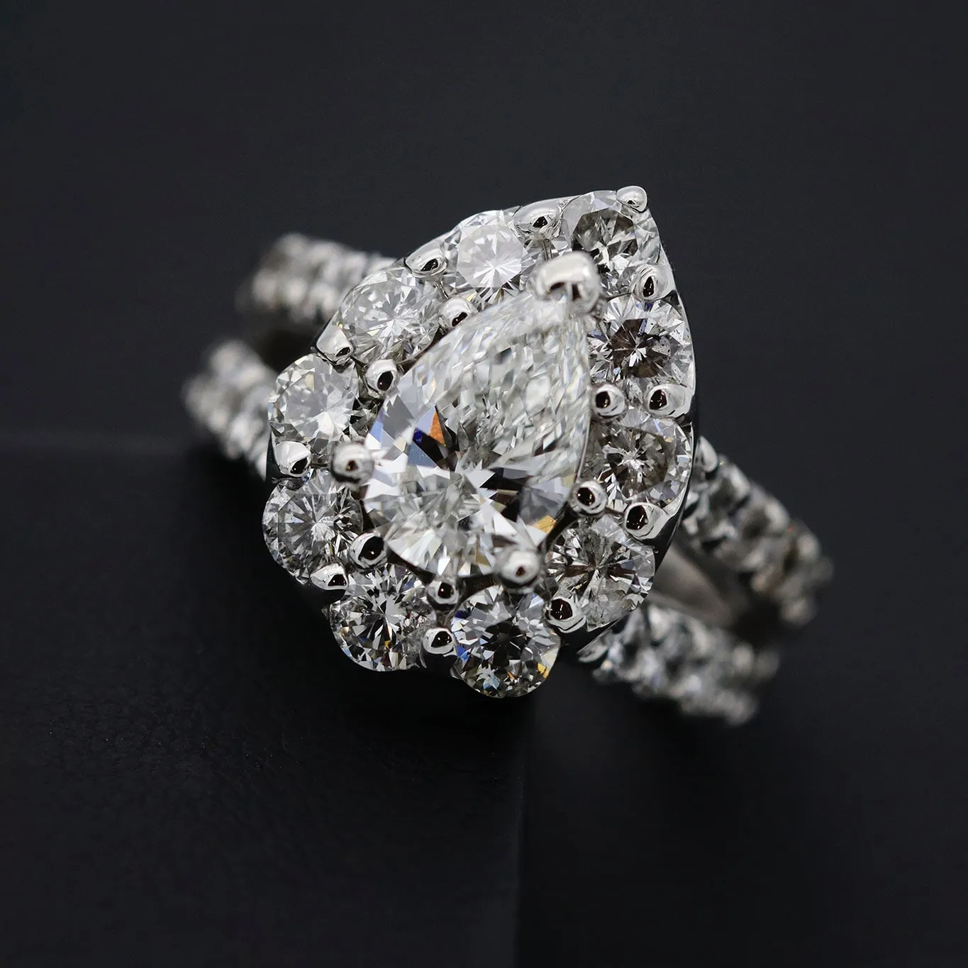 A pear-cut halo engagement ring with matching diamond bands