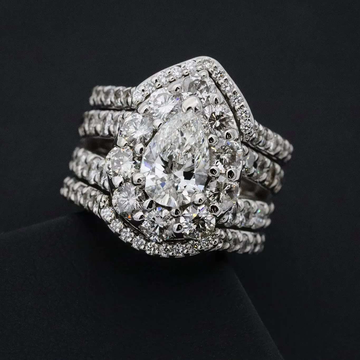 A pear-cut halo engagement ring with matching diamond bands
