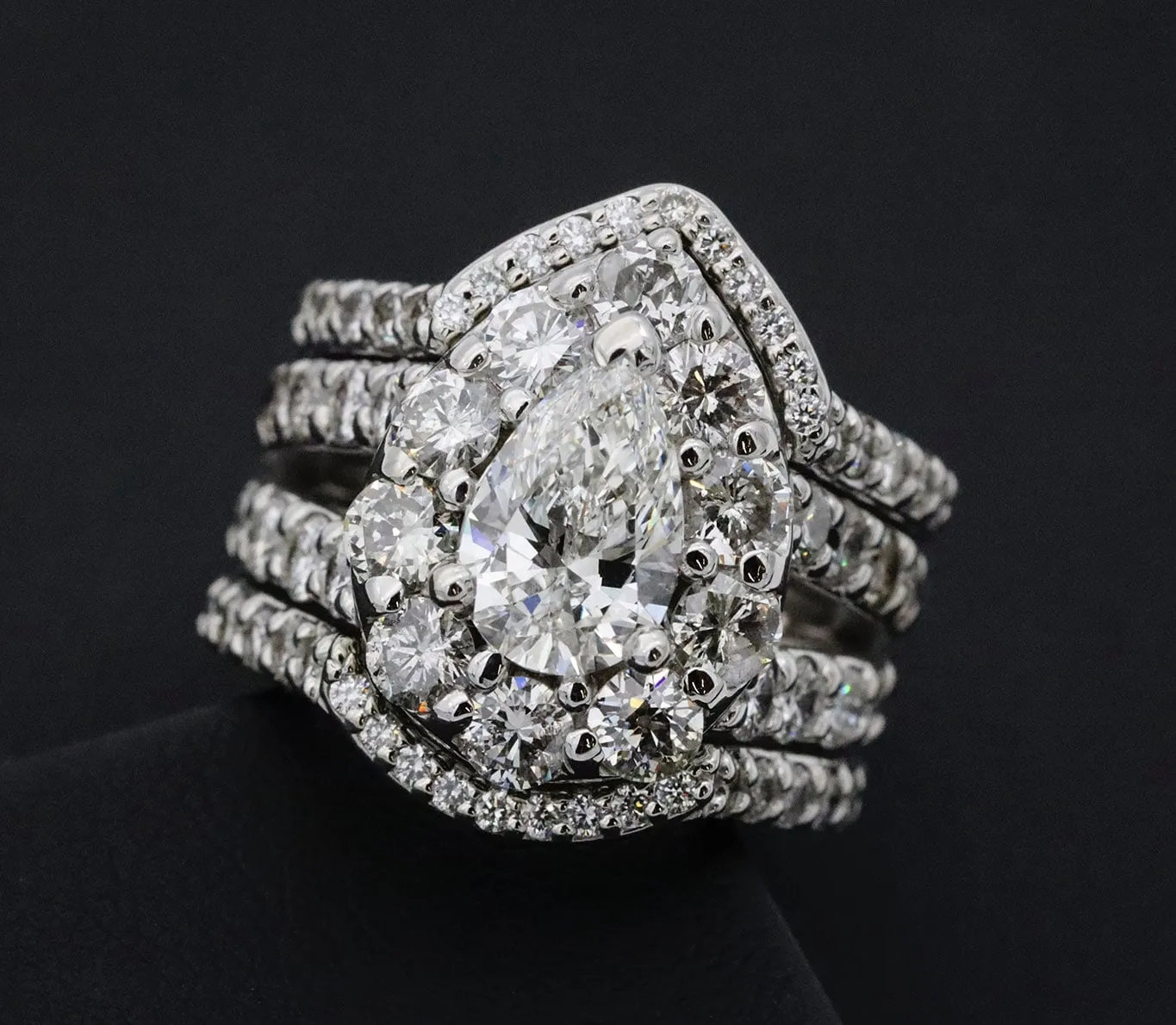 A pear-cut halo engagement ring with matching diamond bands